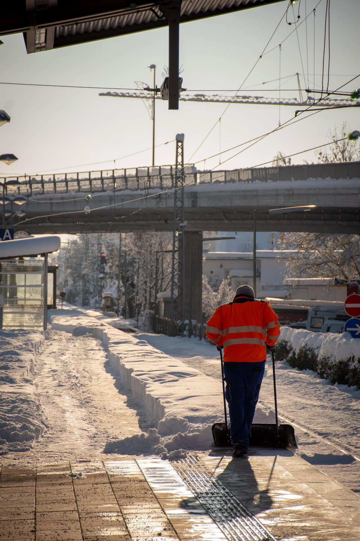 Winterdienst am frühen Morgen: Gehweg wird mit der Schaufel geräumt